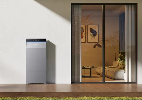 Anker SOLIX X1 battery outside a home, beside glass doors