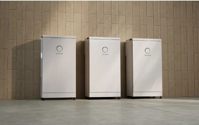Three sonnenBatterie Evo units standing against a timber wall